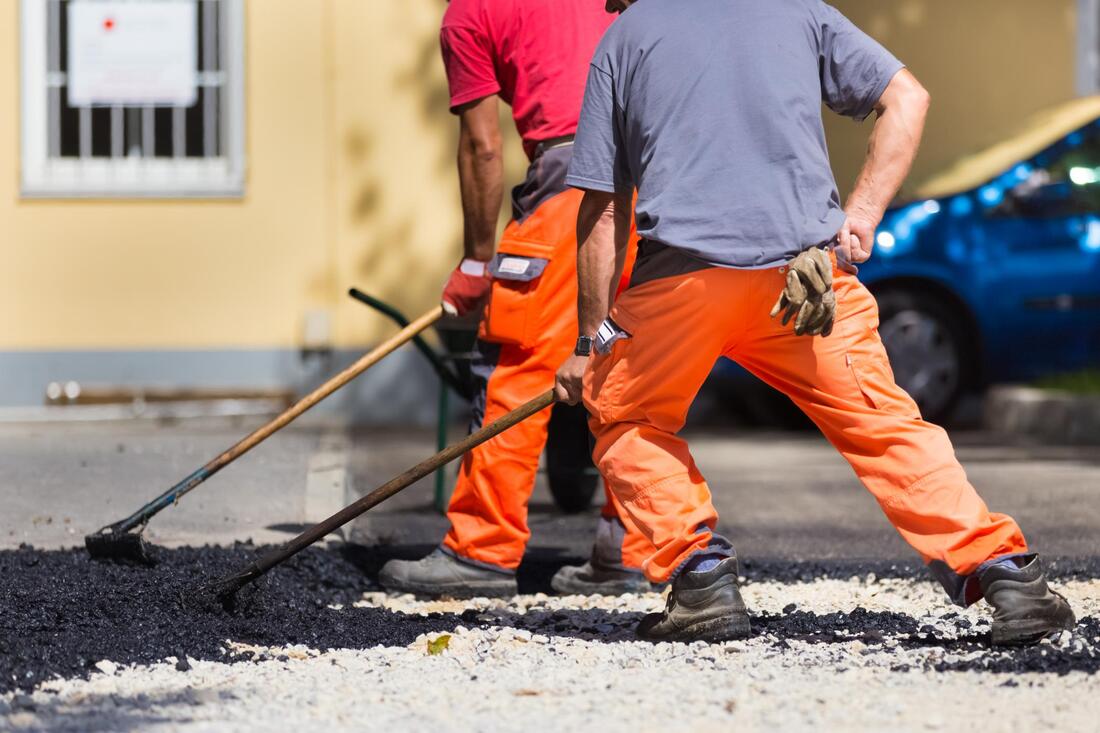 male workers spreading the asphalt
