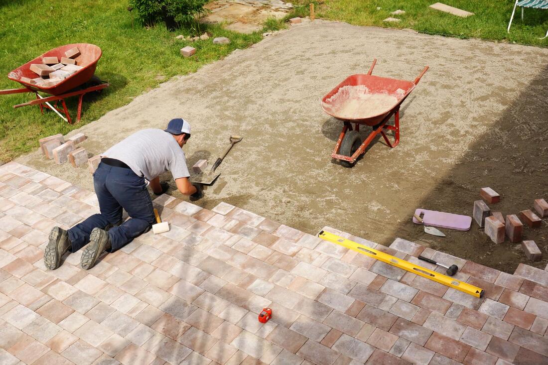 male worker installing brick pavement